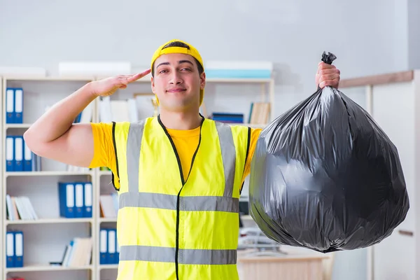Uomo che pulisce l'ufficio e tiene il sacco della spazzatura — Foto Stock