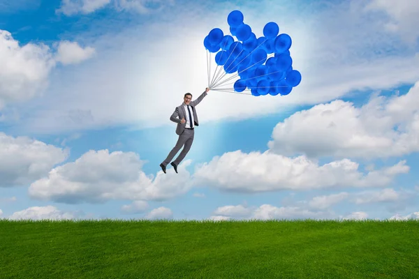 Hombre de negocios volando globos en día brillante — Foto de Stock