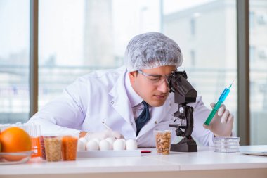 Besin uzmanı gıda ürünlerini laboratuarda test ediyor.