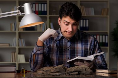 Arkeolog geç saatlere kadar ofiste çalışıyor.