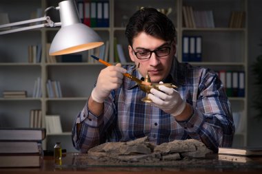 Arkeolog geç saatlere kadar ofiste çalışıyor.