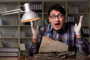 Arkeolog geç saatlere kadar ofiste çalışıyor.