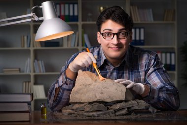 Arkeolog geç saatlere kadar ofiste çalışıyor.