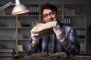 Arkeolog geç saatlere kadar ofiste çalışıyor.