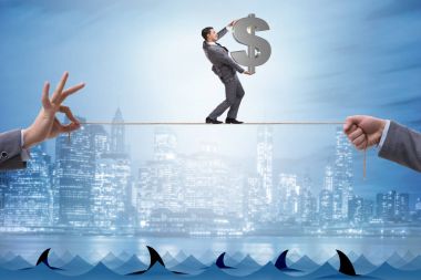 İş adamı iş konseptinde sıkı bir ipin üzerinde yürüyor