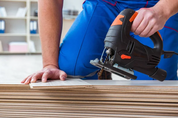 Giovane lavoratore che lavora su pavimenti in laminato — Foto Stock