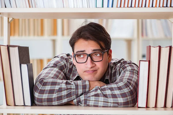 Jonge student op zoek naar boeken in universiteitsbibliotheek — Stockfoto