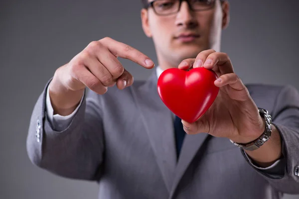 Biznesmen, trzymając czerwone serce w koncepcji miłości — Zdjęcie stockowe