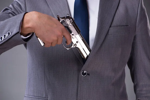 Businessman pulling the gun out of pocket — Stock Photo, Image