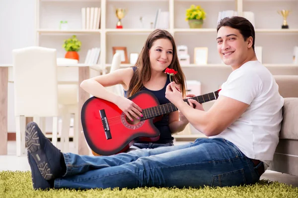 Romantische paar gitaarspelen op verdieping — Stockfoto