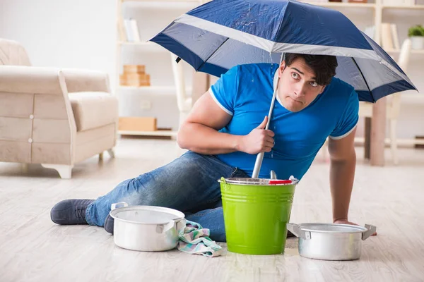 Hombre en casa lidiando con la fuga de inundación del vecino — Foto de Stock