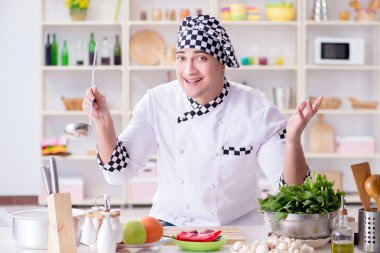 Genç aşçı mutfakta çalışıyor.