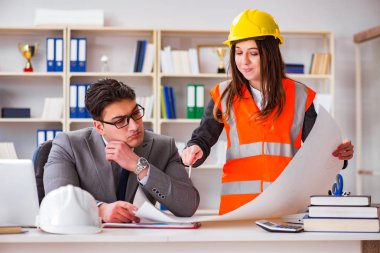 İnşaat ustabaşı çizimleri gözden geçiriyor