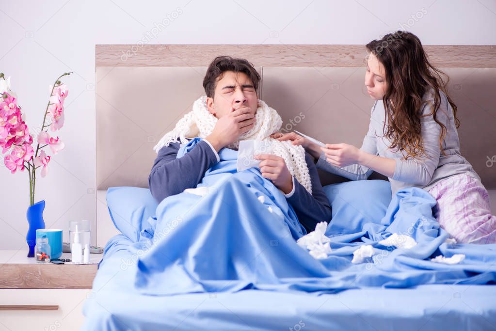 Wife caring for sick husband at home in bed