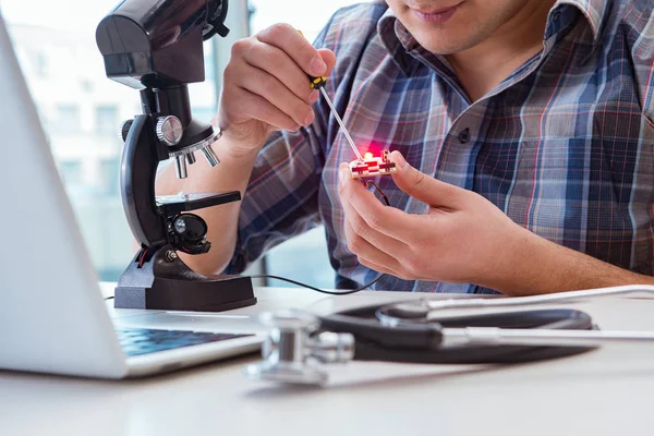 Högprecisionsteknik med man som arbetar med mikroskop — Stockfoto