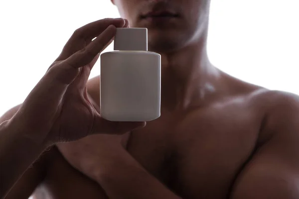 Sexy man with bottle of perfume in low key photo — Stock Photo, Image