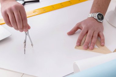 Erkek mühendis çizimler ve planlar üzerinde çalışıyor.