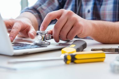 Bilgisayar tamircisi bilgisayar dizüstünü onarıyor