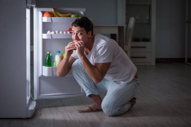 Buzdolabındaki adam gece yemek yiyor.