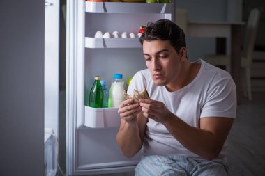 Buzdolabındaki adam gece yemek yiyor.