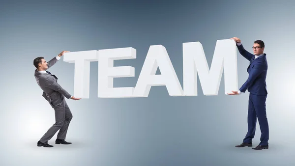 Uomini d'affari in possesso di word team nel concetto di lavoro di squadra — Foto Stock