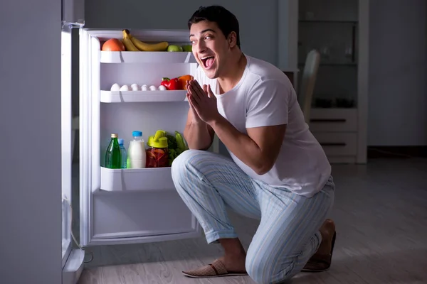 Man aan de koelkast 's nachts aan het eten — Stockfoto