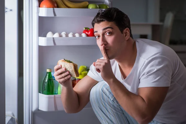 Hombre en el refrigerador comiendo por la noche — Foto de Stock