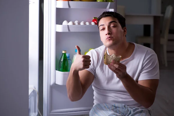 Hombre en el refrigerador comiendo por la noche — Foto de Stock