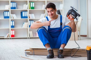 Zemin kaplamalarında çalışan genç bir işçi.