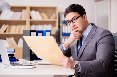 İşadamı mektup zarfını ofisinde alıyor.