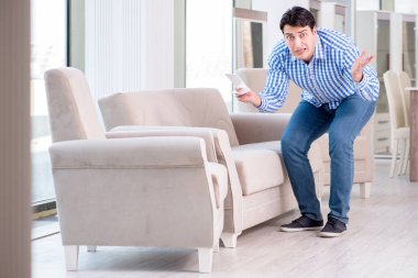 Genç adam mobilya dükkanından alışveriş yapıyor.