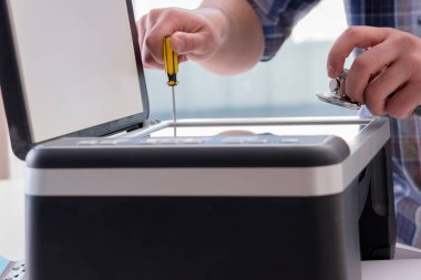 Tamirci bozuk renk yazıcısını tamir ediyor