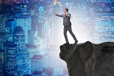 Uçurumun kenarında duran gözü bağlı iş adamı