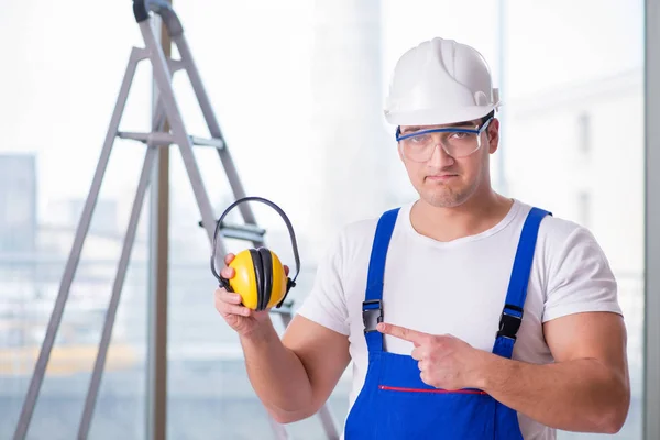 Junger Arbeiter mit lärmintensiven Kopfhörern — Stockfoto