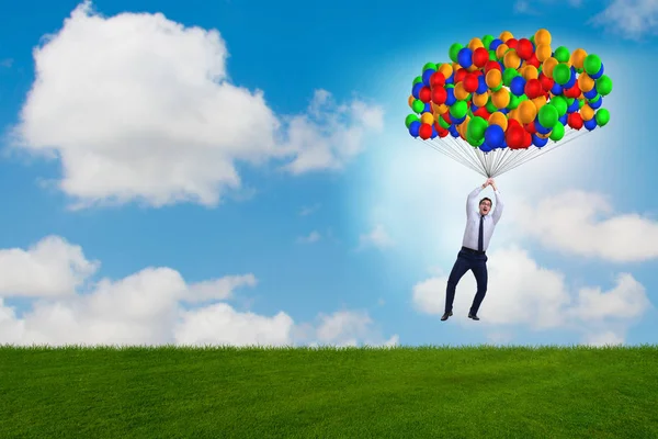Affärsman flygande ballonger på ljusa dagen — Stockfoto