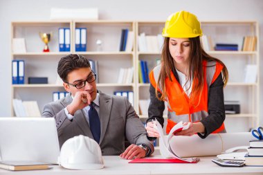 İnşaat ustabaşı çizimleri gözden geçiriyor