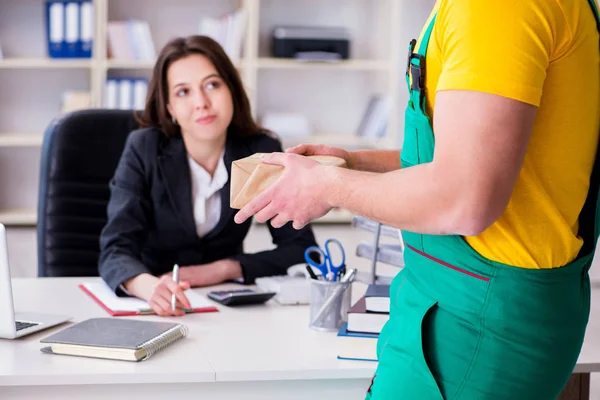 Postbode bezorgt pakketje op kantoor — Stockfoto