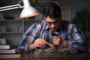 Arkeolog geç saatlere kadar ofiste çalışıyor.