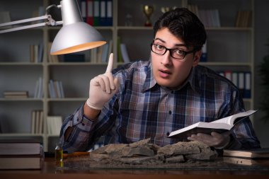 Arkeolog geç saatlere kadar ofiste çalışıyor.