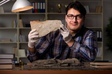 Arkeolog geç saatlere kadar ofiste çalışıyor.