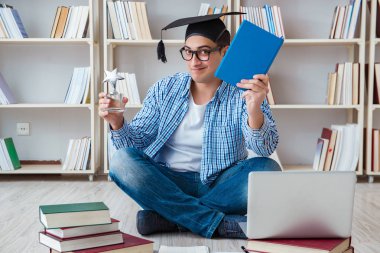 Genç öğrenci kitaplarla çalışıyor.