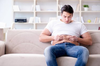 Diyet konseptinde fazladan ağırlık çeken adam.