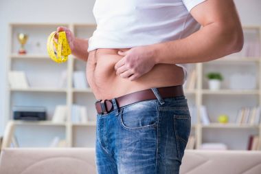 Diyet konseptinde fazladan ağırlık çeken adam.