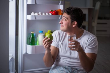 Buzdolabındaki adam gece yemek yiyor.