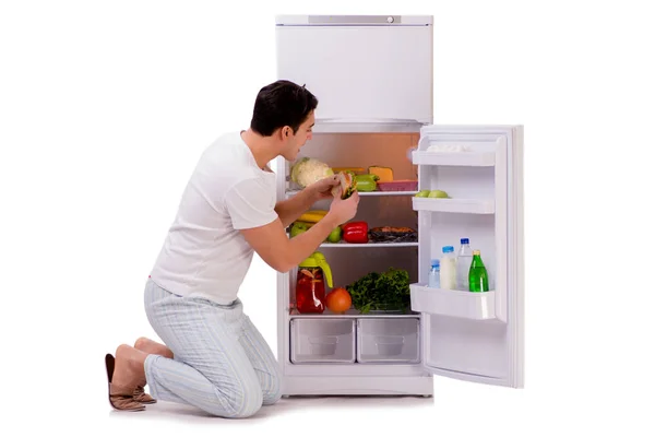 Человек рядом с холодильником полный еды — стоковое фото