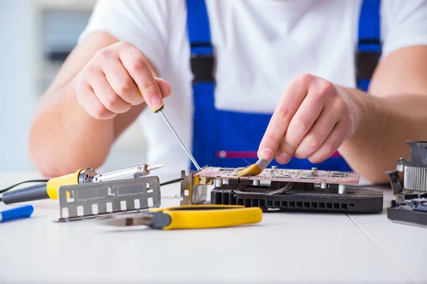 Computer repairman repairing desktop computer