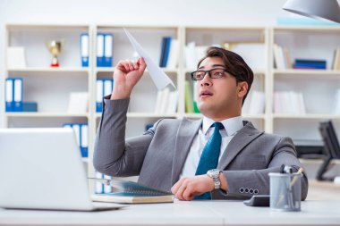 Ofisinde kağıt uçak olan bir iş adamı.