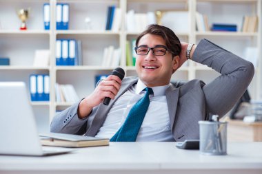 İş adamı ofiste şarkı söylüyor.