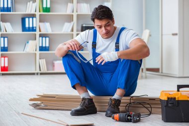 Zemin kaplamalarında çalışan genç bir işçi.