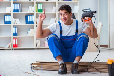 Zemin kaplamalarında çalışan genç bir işçi.